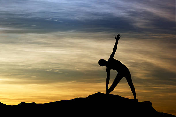 istock Silhouette of woman practicing yoga at sunset 624098232