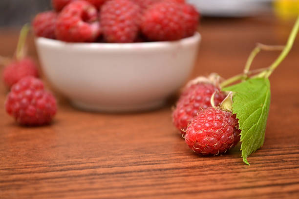 istock Raspberries in white plate on a wooden table. 624099010