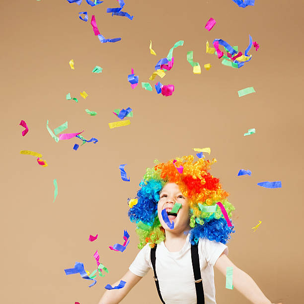 istock Little boy in clown wig jumping and having fun 624099258