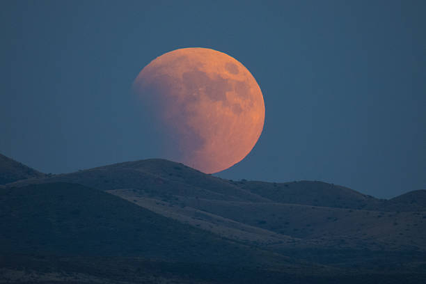Eclipsing Moon Super-blood moon rises over the Dragoon Mountains as viewed from Tombstone, Arizona lunar eclipse stock pictures, royalty-free photos & images