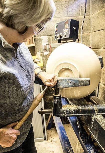 istock senior woman using chisel and lathe to create wooden bowl 624100914