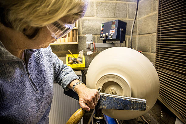 istock senior woman using chisel and lathe to create wooden bowl 624100976