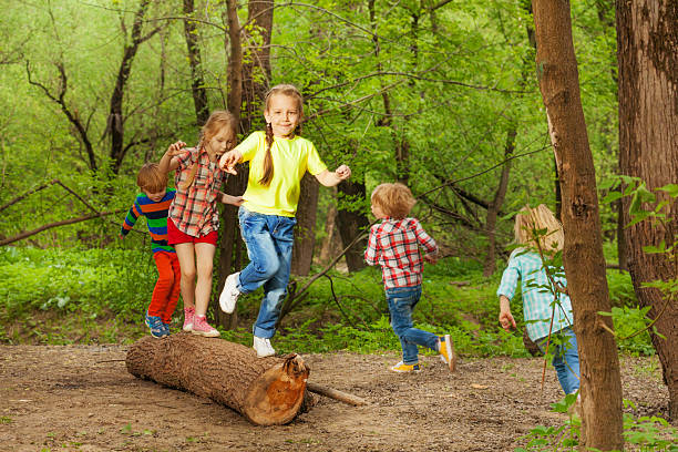 istock Cute little kids playing on a log in the forest 624102304