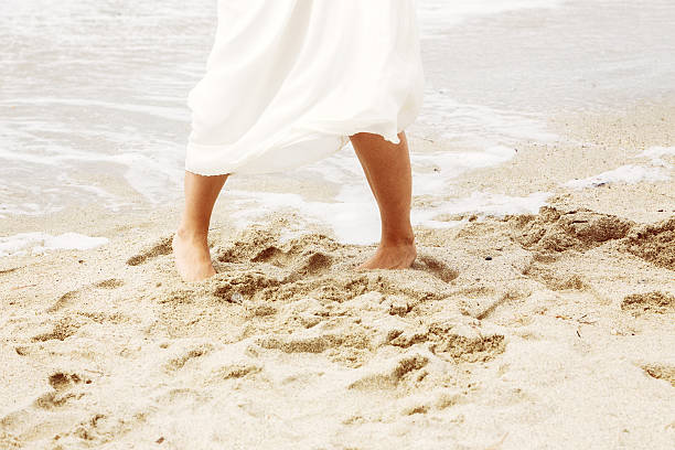 istock woman in white dress on beach. 624102324