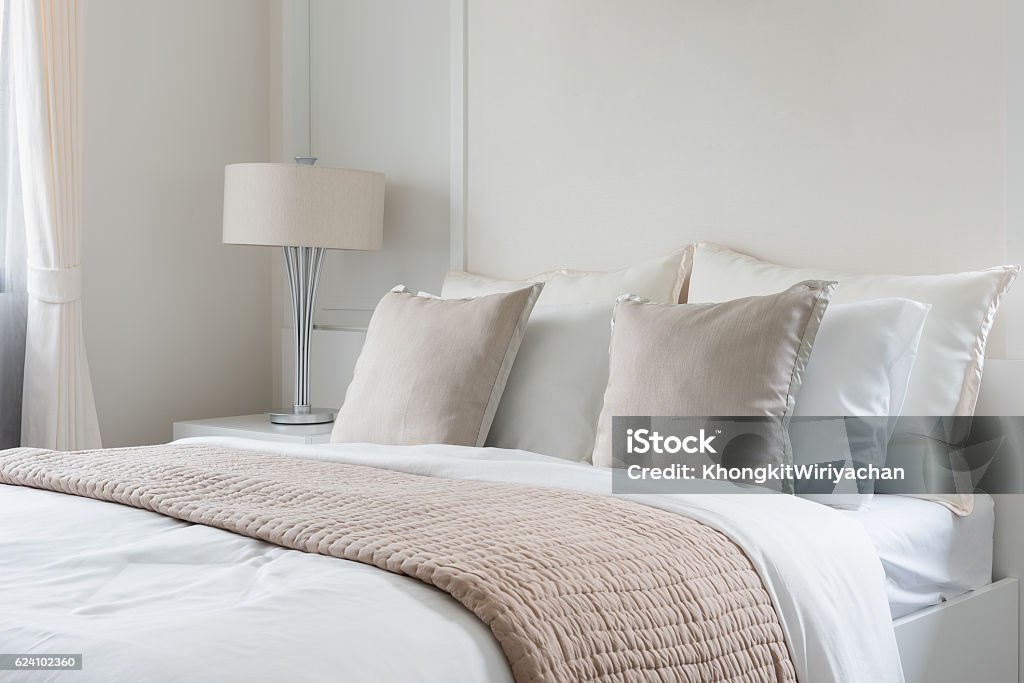 modern lamp on table side with picture frame on wall modern lamp on table side with picture frame on wall in bedroom design Bed - Furniture Stock Photo
