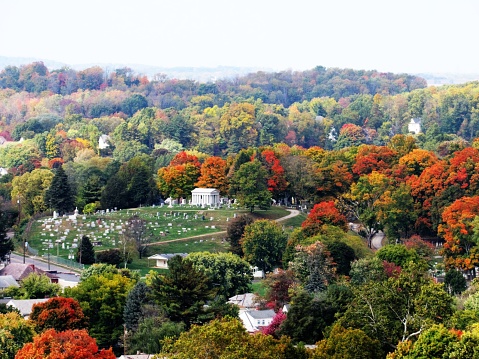 Cementerio distante rodeado de árboles de colores en otoño photo