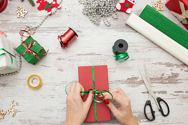 istock Hands of woman decorating Christmas gift box 624107782