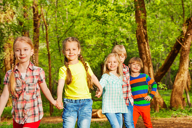 istock Happy friends walking in the forest holding hands 624108236