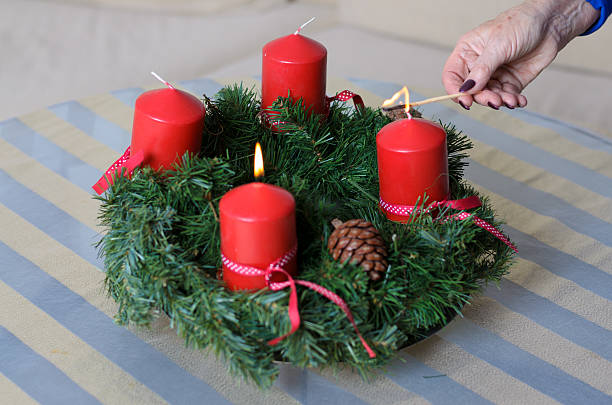 istock Woman lighting candles on a Christmas wreath 624109144