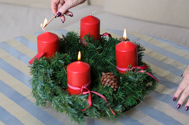 istock Woman lighting candles on a Christmas wreath 624110106
