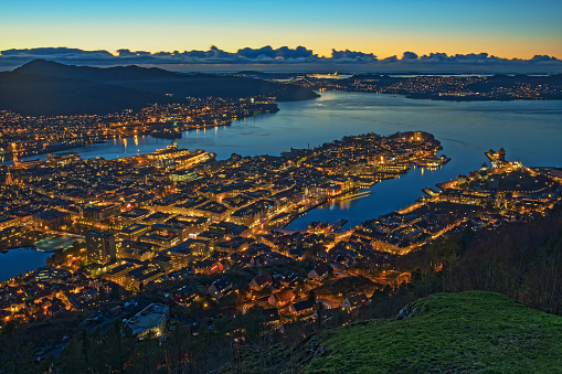 Panoramic aerial view on illuminated Bergen harbor and city at dusk, Norway.