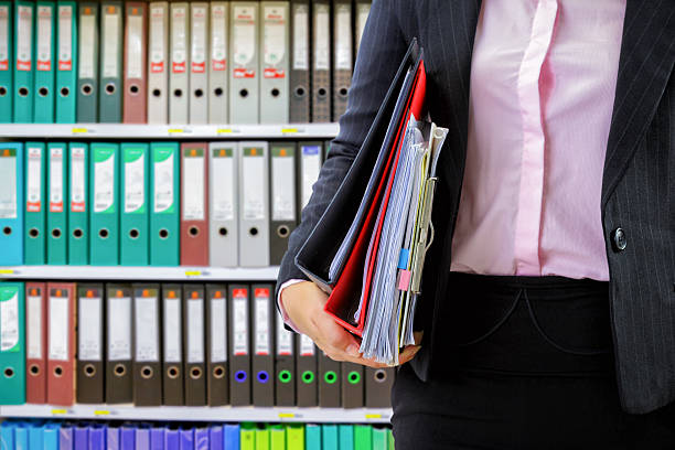 istock businesswoman holding data files on binder shelves background 624117330