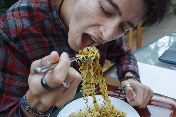 istock Young enterprising boy eating ramen at lunchtime. 624117696