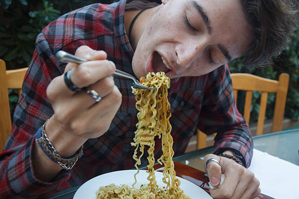 istock Young enterprising boy eating ramen at lunchtime. 624117966