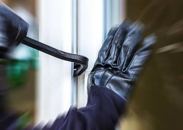 A burglar opens a window with a breaker.