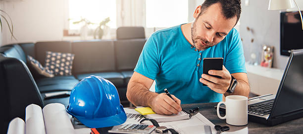 hombre escribiendo notas y sosteniendo el teléfono inteligente - built structure coffee blueprint engineering fotografías e imágenes de stock