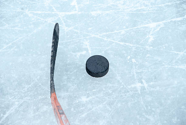 istock ice hockey stick and puck on ice 624137754