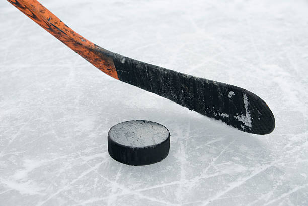 istock ice hockey stick and puck on ice 624137766