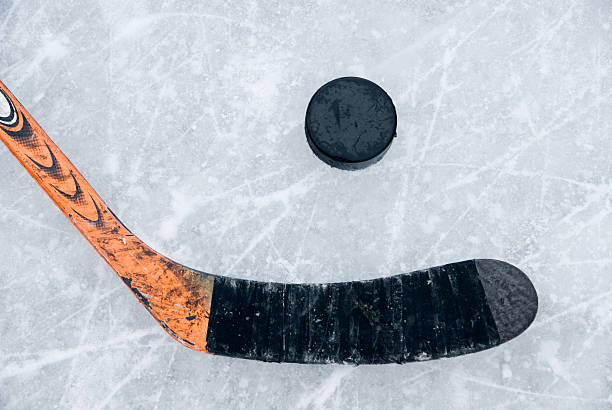 istock ice hockey stick and puck on ice 624137806
