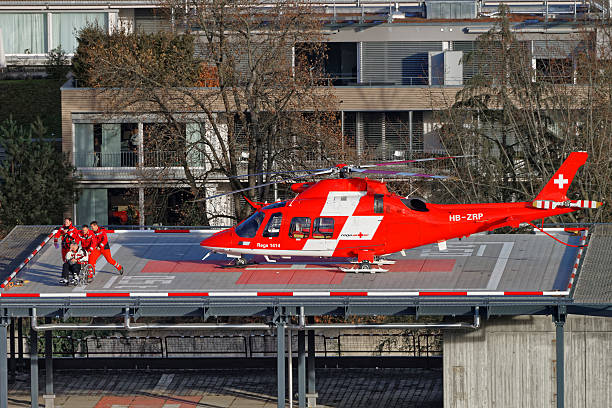 Helicopter and patient on the hospital roof in Thun City Thun, Switzerland - January 1, 2014: Helicopter and patient on the hospital roof in Thun City. Thun is a city in the canton of Bern in Switzerland. There is a view of Bernese Alps. lake thun stock pictures, royalty-free photos & images