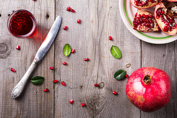 istock Broken and whole red ripe juicy pomegranates on rustic wooden 624155226