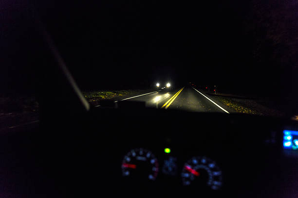 rural highway night time approaching vehicle headlights - car dashboard night driving imagens e fotografias de stock