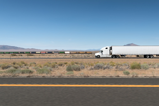Freight train and Truck passing through on the American Highway. Nikon D810. Converted from RAW.