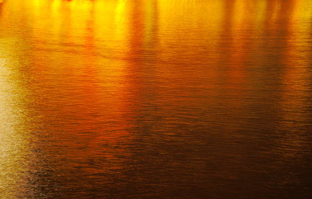 istock golden city light reflection on the water background 624169450