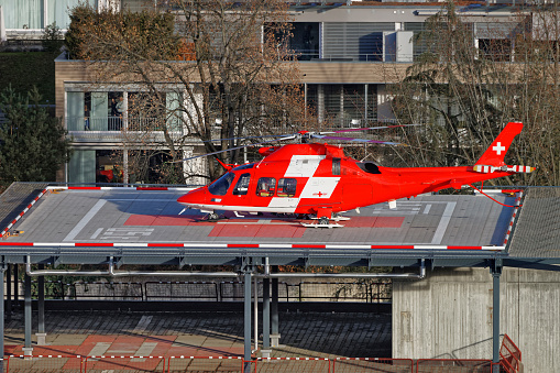 Thun, Switzerland - January 1, 2014: Emergency Helicopter on the hospital roof of the Thun City. Thun is a city in the canton of Bern in Switzerland. There is a view of Bernese Alps.