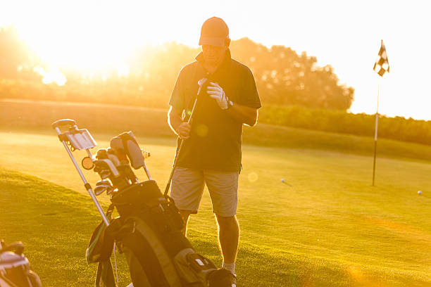 istock golfer on sunset with flares 624172358