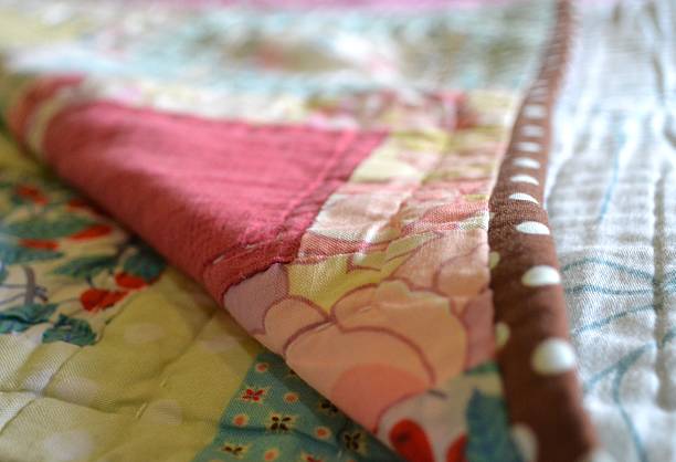 Hand made quilt folded back to reveal stitches stock photo