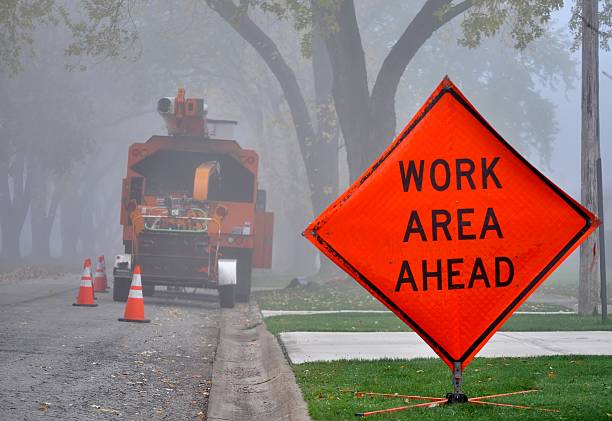 panneau routier orange et véhicule de service dans la matinée brumeuse. - broyeur de branches photos et images de collection