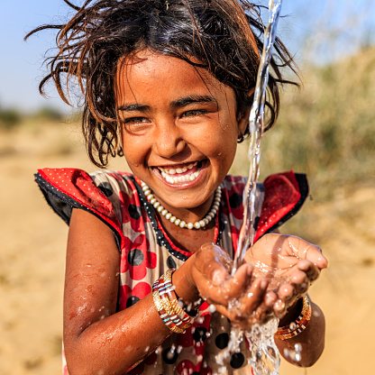 Indio poco Chica beber agua fresca del desierto village, Rajastán de India photo