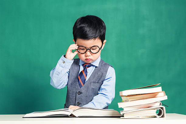 istock Little boy sitting at table and reading 624183090