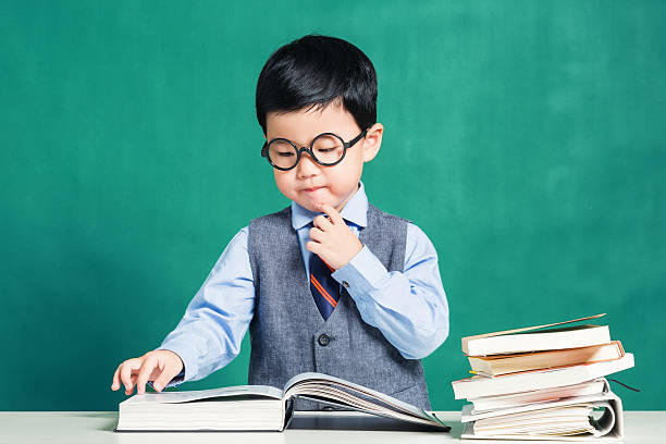 istock Little boy sitting at table and reading 624183126