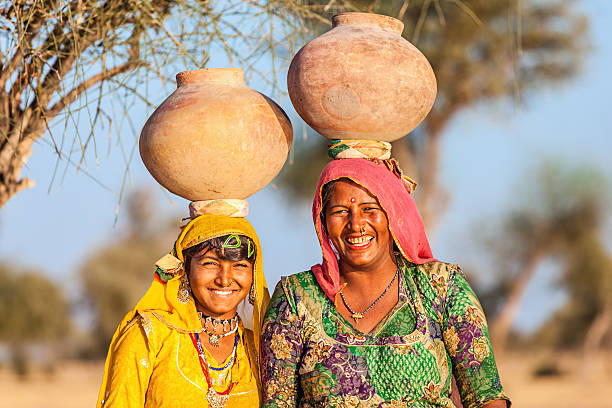 Sabbalpura, India - March 15, 2014:  Happy traditionally dressed Indian women in saris laughing while standing in the street of their village.