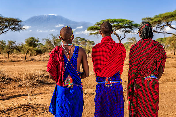 Warriors from Maasai tribe looking at Mount Kilimanjaro, Kenya, Africa African warriors from Maasai tribe, Mount Kilimanjaro on the background, central Kenya, Africa. Maasai tribe inhabiting southern Kenya and northern Tanzania, and they are related to the Samburu. kenyan culture stock pictures, royalty-free photos & images