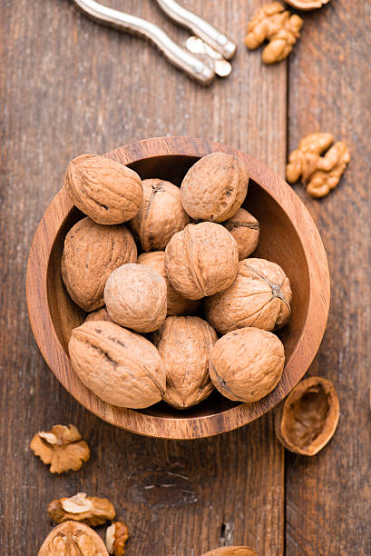 istock Walnuts in wooden bowl on table with Nutcracker. Top view. 624194128