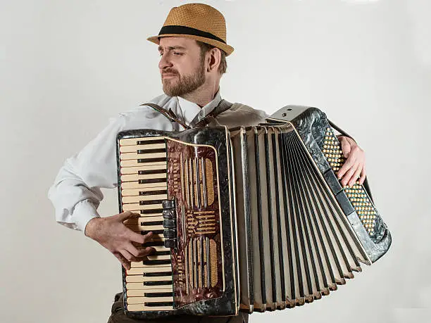 The musician playing the accordion on white background