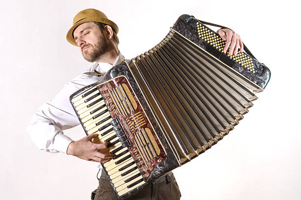 Portrait of a man emotionally playing the accordion Portrait of a man wearing a straw hat and a white shirt emotionally playing the accordion accordion stock pictures, royalty-free photos & images