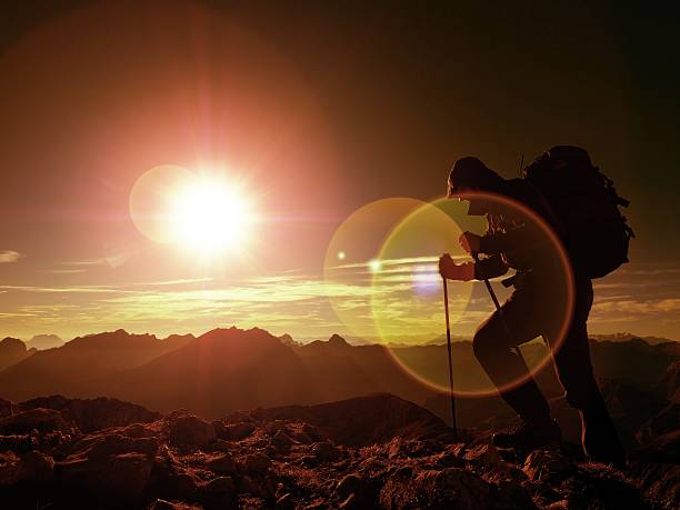 istock Lens flare defect.Man hiker with rucksack on peak. Man walking 624196728