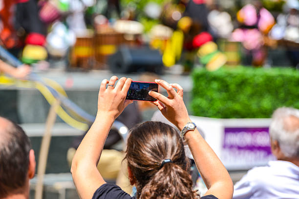 San Francisco, USA  - May 19, 2013: Woman filming with mobile phone outdoors live concert on Union Square, San Francisco