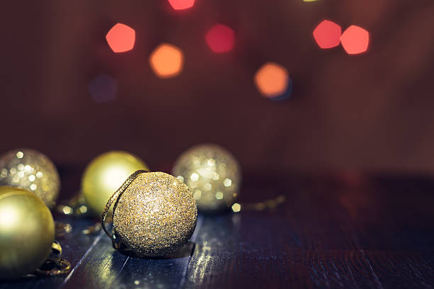 istock Christmas tree yellow baubles on black wooden table. 624208338