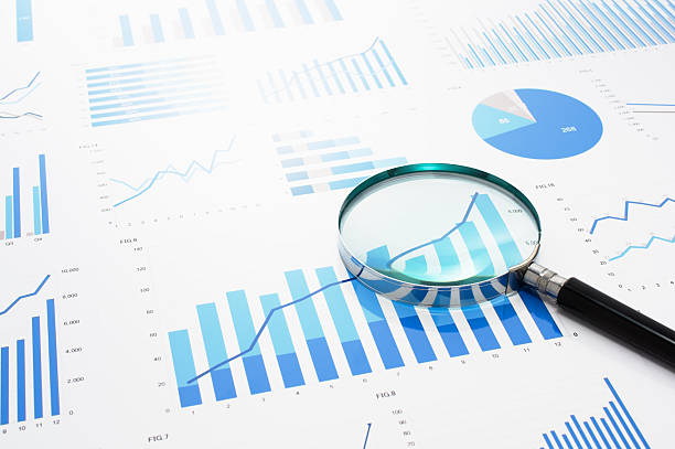 istock Many charts and magnifying glass. Reviewing data. 624227216