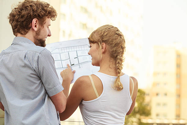 istock couple with blueprint project  building plans outdoor 624250466
