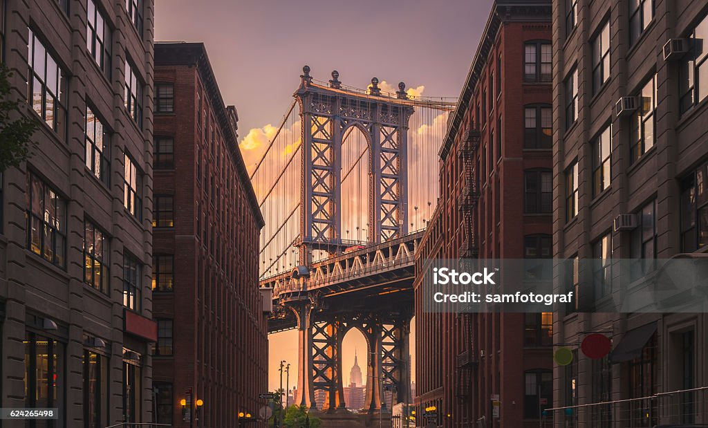 Manhattan Bridge, NYC Manhattan bridge seen from a brick buildings in Brooklyn street in perspective, New York, USA. Shot in the evening New York City Stock Photo