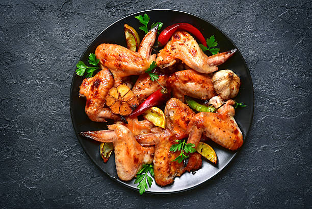 asas de frango grelhadas em um prato preto. vista superior. - wing chicken barbecue grilled - fotografias e filmes do acervo