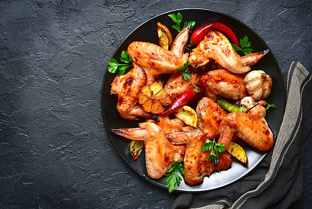 istock Grilled chicken wings on a black plate.Top view. 624280948