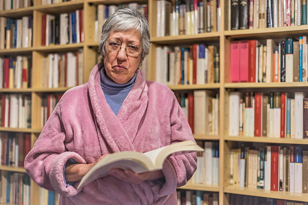 istock Senior woman reading a book at home. Serious expression. 624281478