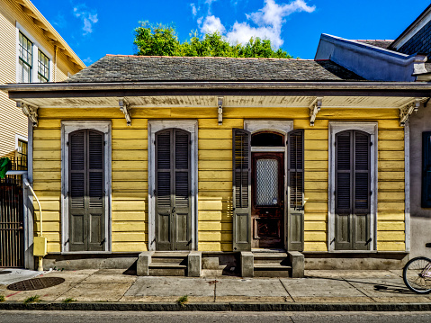 New Orleans LA USA -  Sep. 13, 2016  - Yellow Shotgun House with Shutters and Door in the French Quarter, New Orleans.